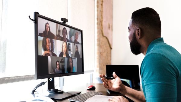 Man consulting with people on a screen